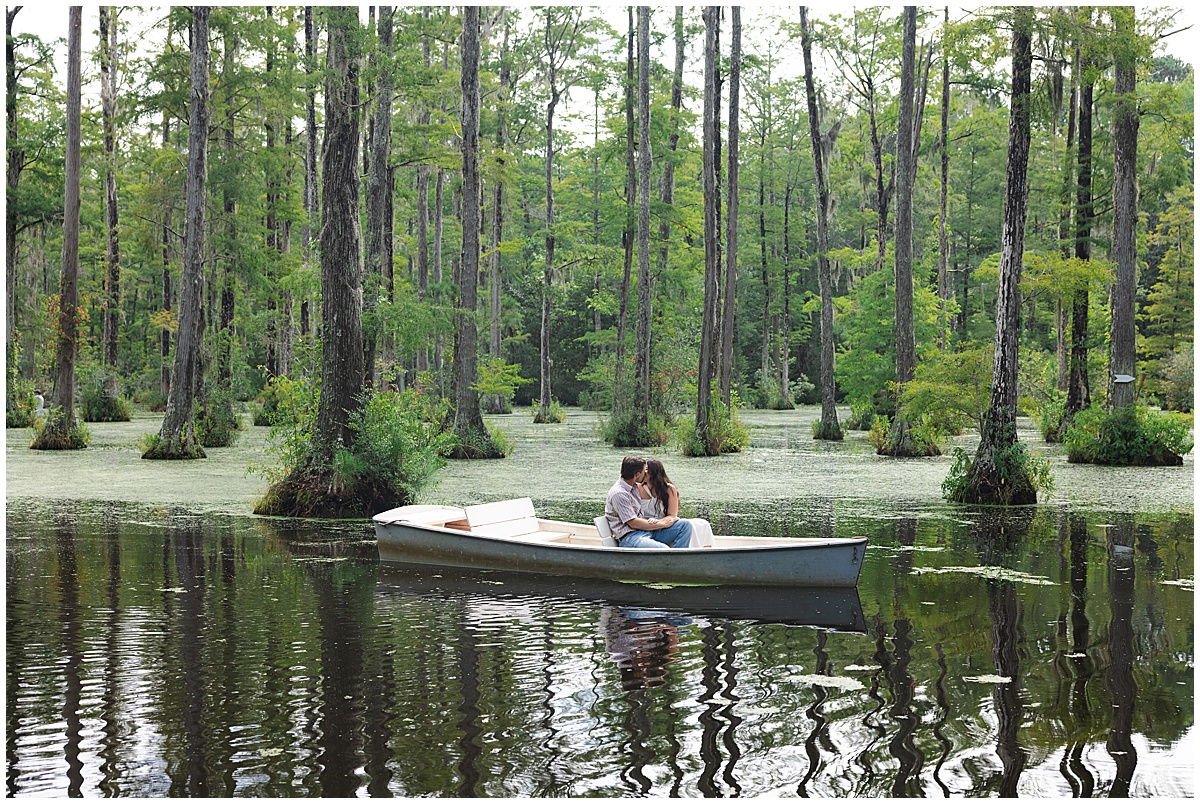 A couple sits close together on a row boat at Cypress Gardens. A notebook-inspired engagement photoshoot